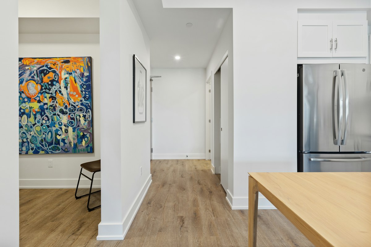Kitchen passage beside cabinetry, a refrigerator and a wooden counter edge