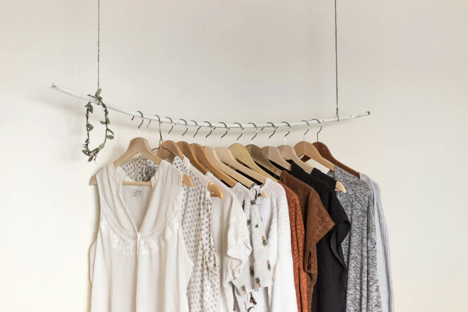 Light-coloured shirts and textured garments hang on a clothing rail